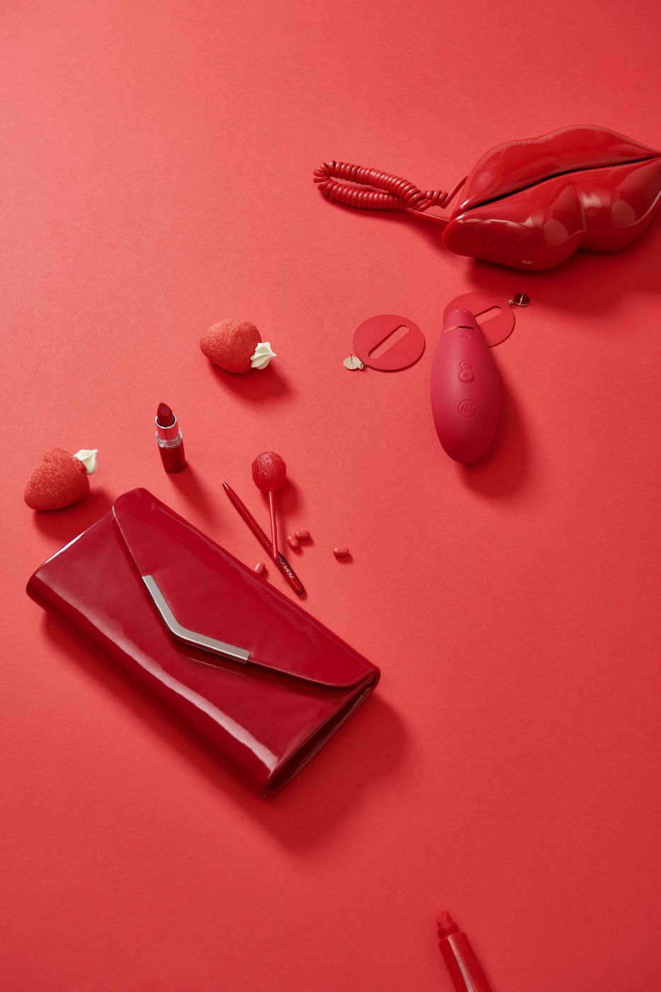 Red flat lay with lipstick, clutch and a wellness massager